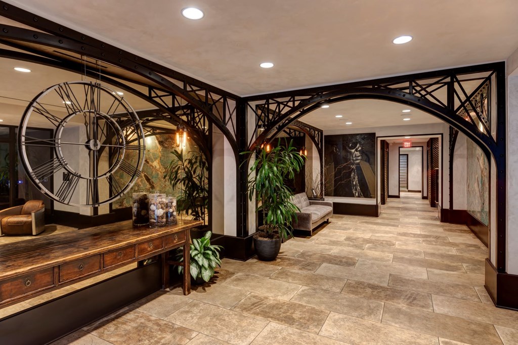 a lobby with a large clock on the wall and a bench