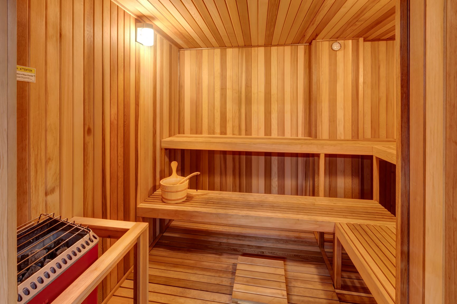 a sauna with a wooden bench and a bucket