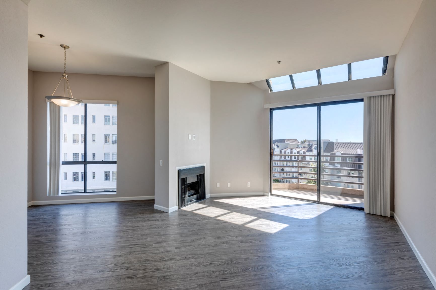 One Bedroom Apartments in Hancock Park, CA - Apartment Dining Room, Living Room with Fireplace and Sliders to Balcony