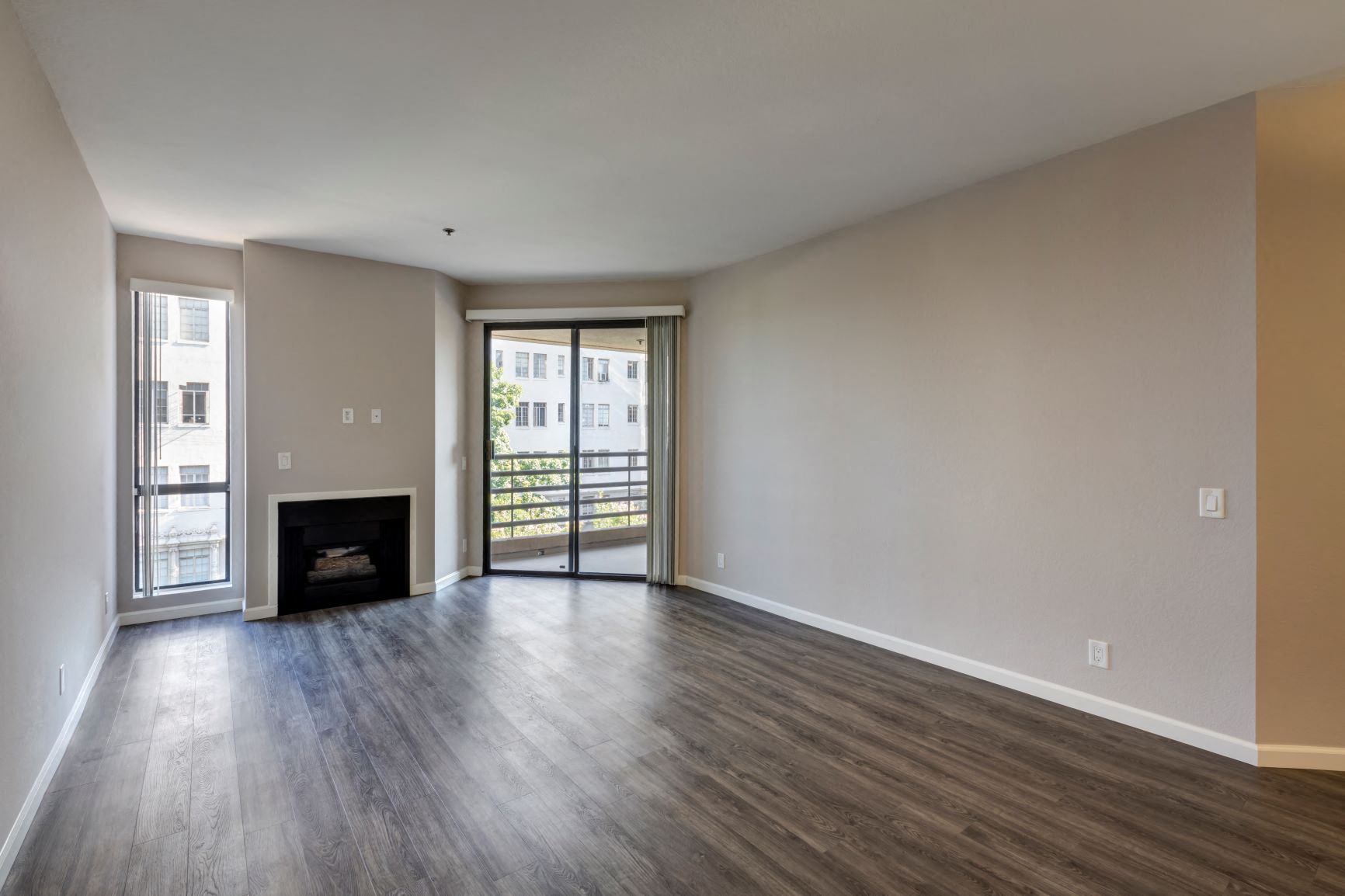 Two Bedroom Apartments in Hancock Park, CA - Apartment Living Room with Fireplace, Window and Sliders to Balconly