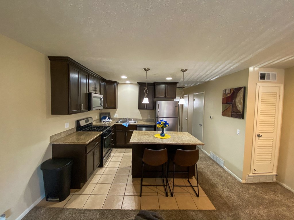 a kitchen with a island with chairs and a sink
