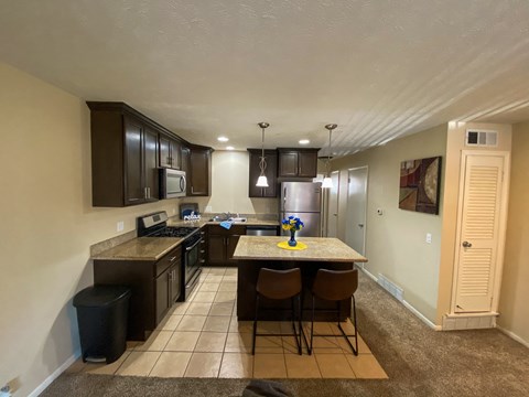 a kitchen with a island with chairs and a sink