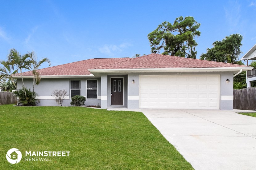 a white house with a lawn and a driveway