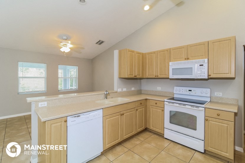 a kitchen with white appliances and wooden cabinets