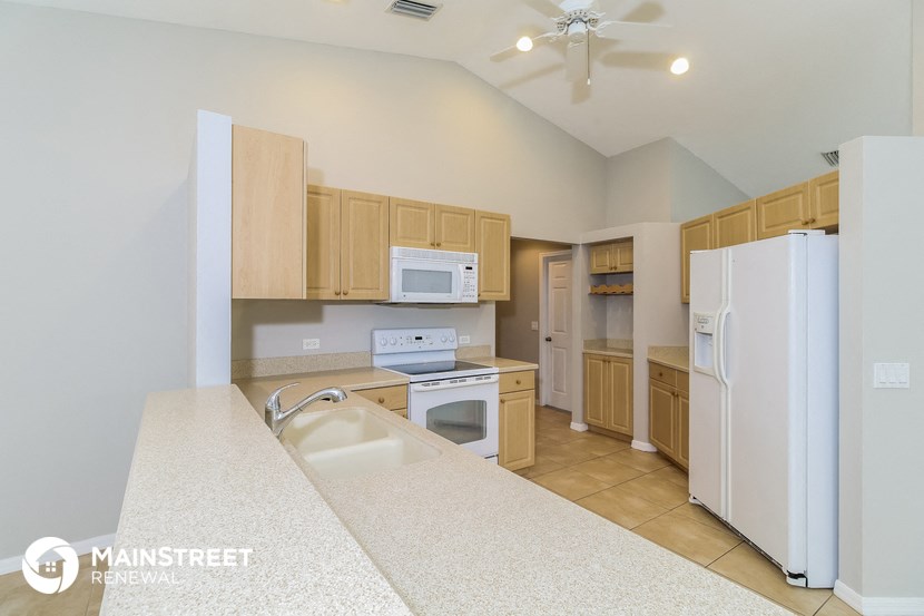 a kitchen with white appliances and wooden cabinets