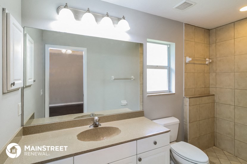 a bathroom with a large mirror and a sink and a toilet