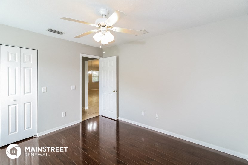 a living room with wood flooring and a ceiling fan