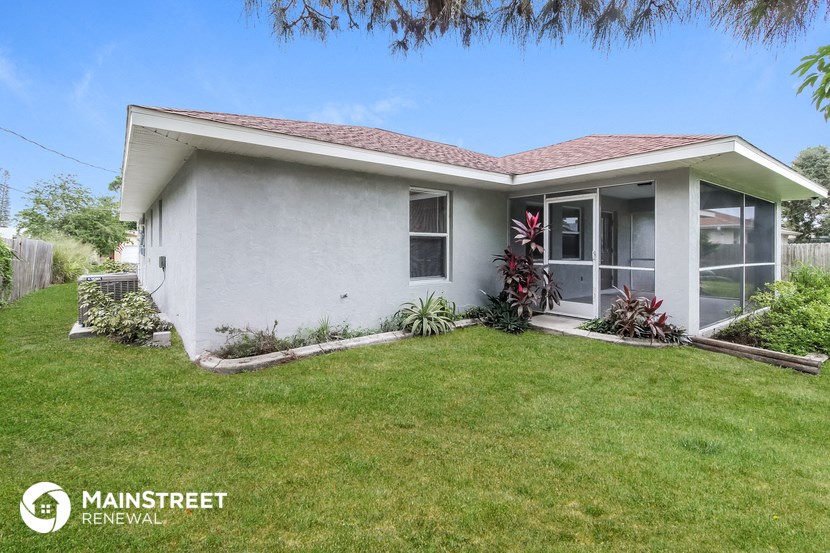 a small white house with a lawn and a porch