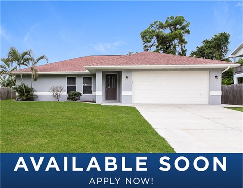 a small white house with a lawn and a driveway