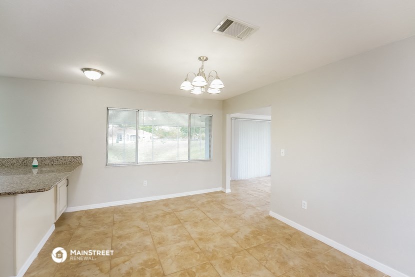 the spacious living room and dining room with a large window