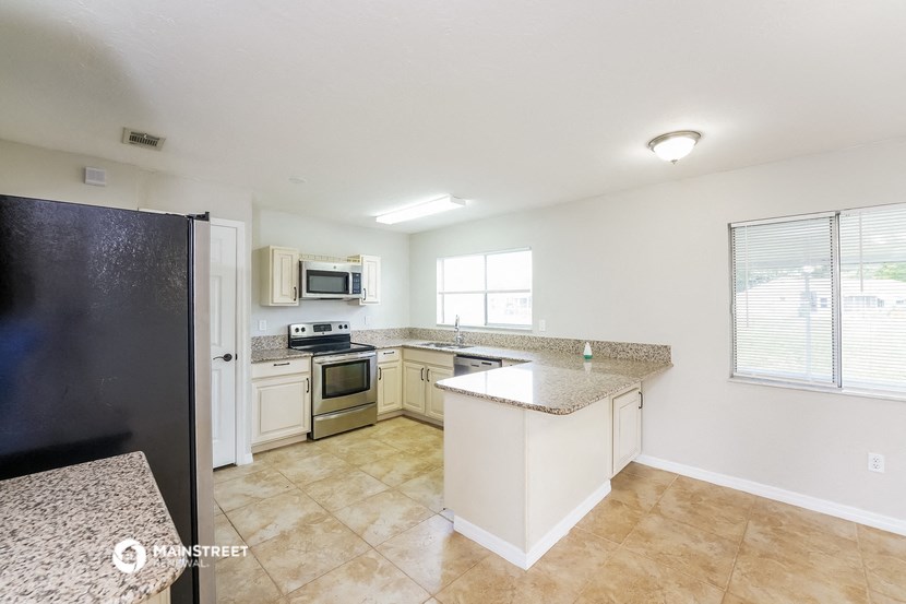 an empty kitchen with granite counter tops and stainless steel appliances