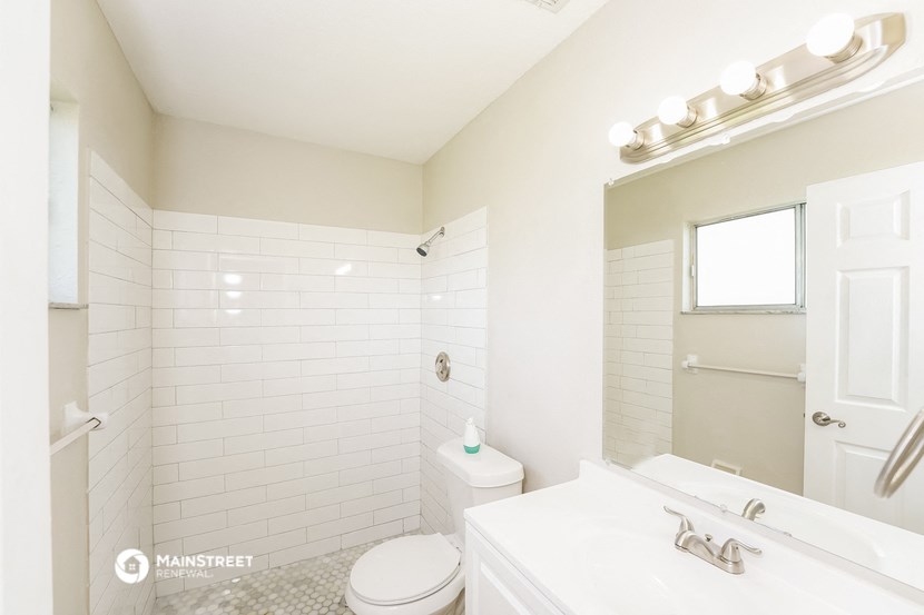 a bathroom with a sink toilet and a mirror