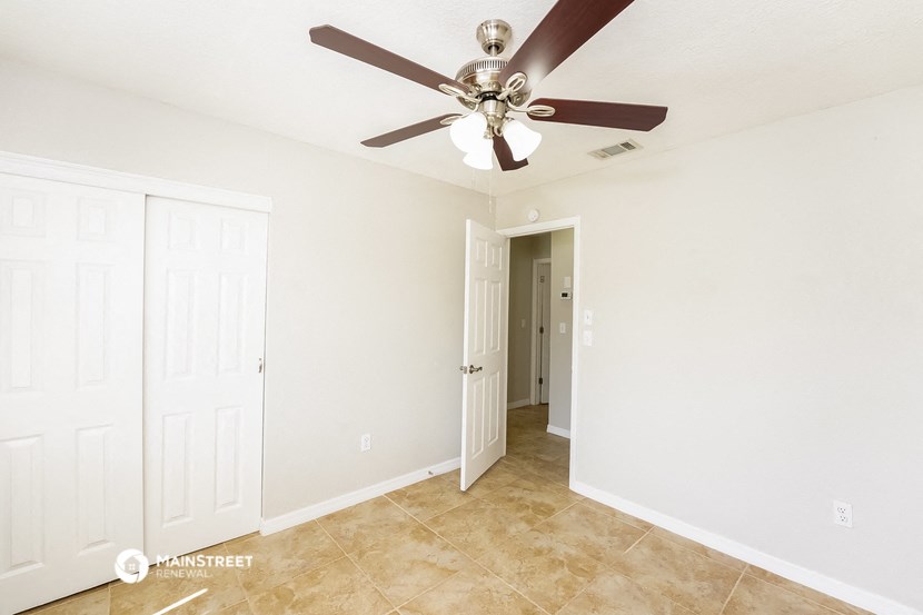 a bedroom with a ceiling fan and a closet