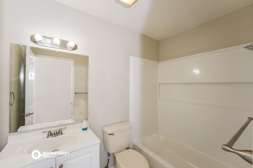 a bathroom with a toilet and a sink and a bath tub