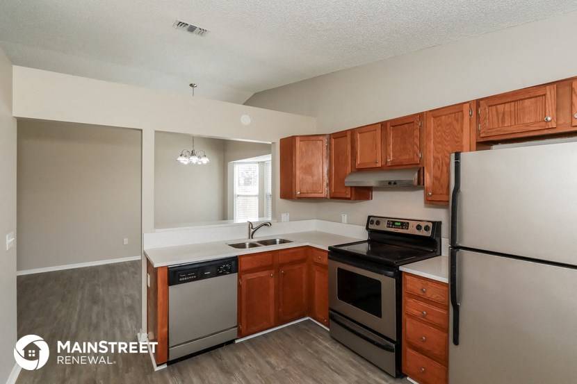 a kitchen with wooden cabinets and stainless steel appliances