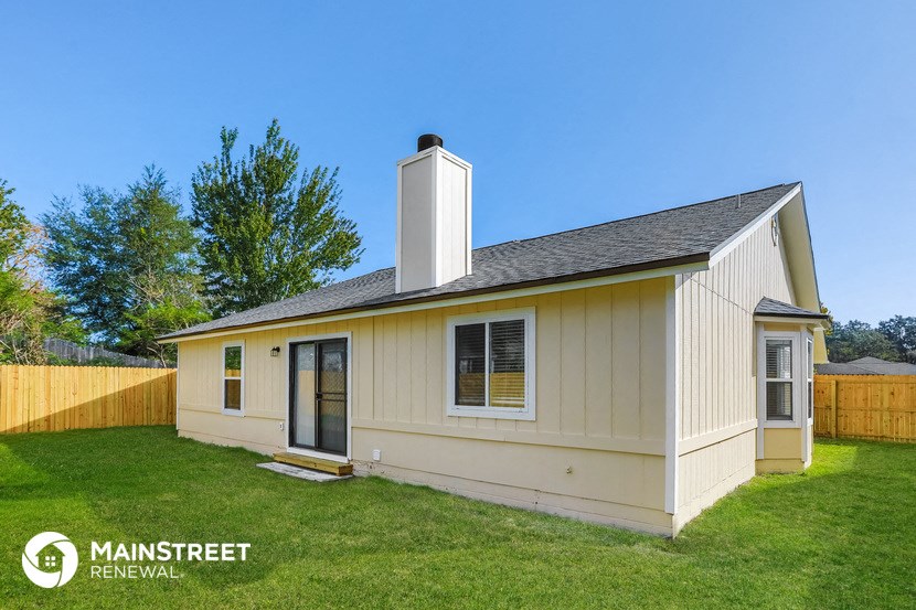 a small yellow and with a fence and grass