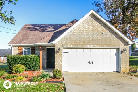 a small brick house with a white garage door