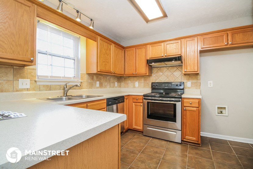 a kitchen with wooden cabinets and stainless steel appliances