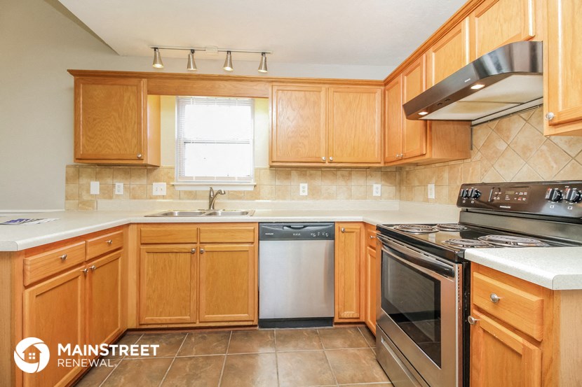 a kitchen with wooden cabinets and stainless steel appliances