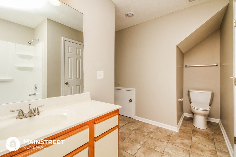a bathroom with a toilet and a sink and a mirror