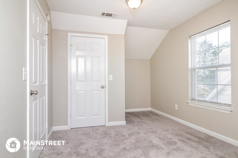 a bedroom with a white door and a window