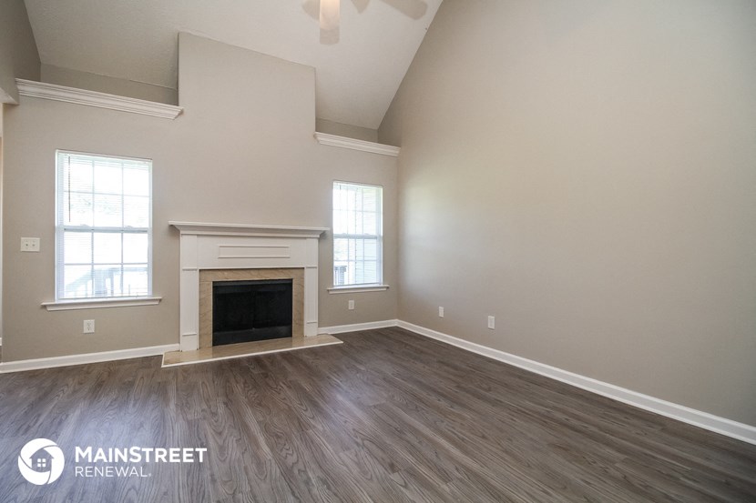 the spacious living room with fireplace and hardwood flooring