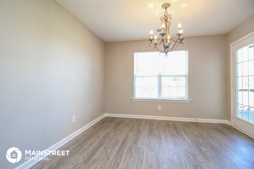 the spacious living room with wood flooring and a chandelier
