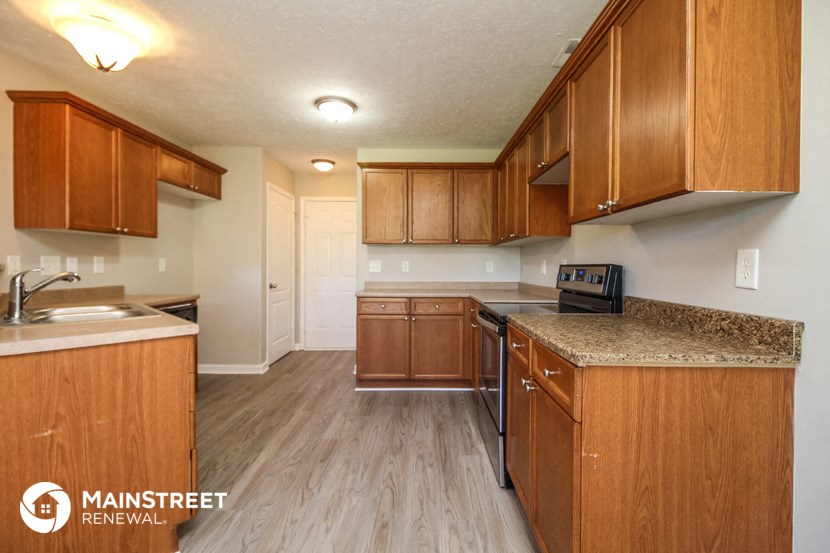 a kitchen with wooden cabinets and granite counter tops and a sink