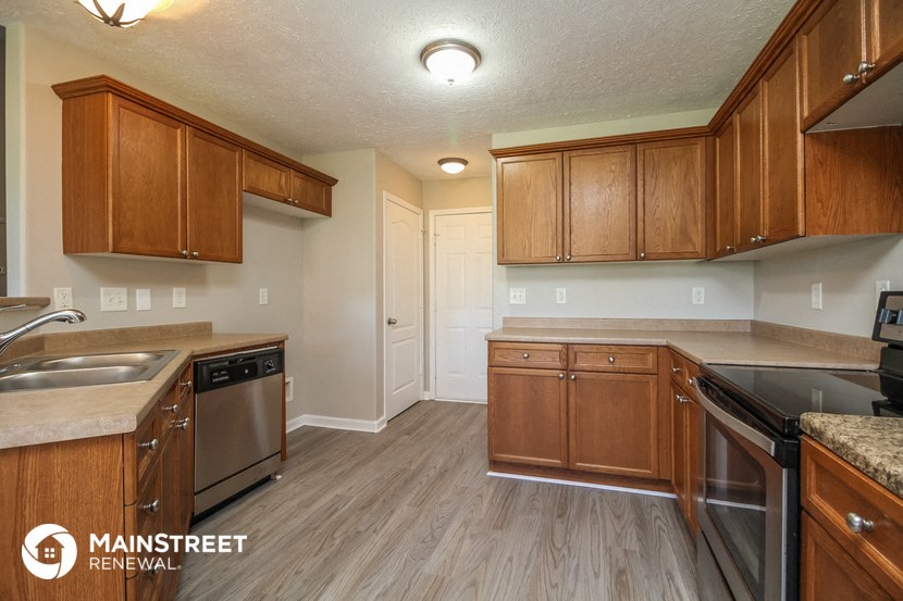 a kitchen with wooden cabinets and stainless steel appliances