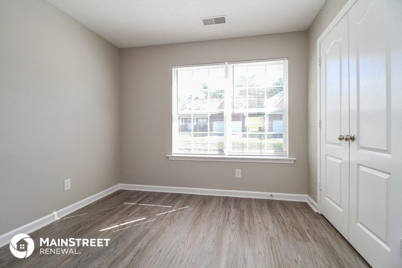 the living room of a new home with vinyl flooring and a large window