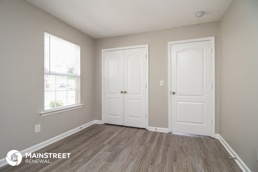 the interior of an empty room with two doors and a window