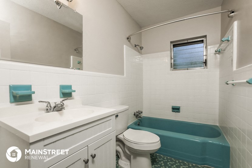 a bathroom with a blue tub and a sink and a toilet