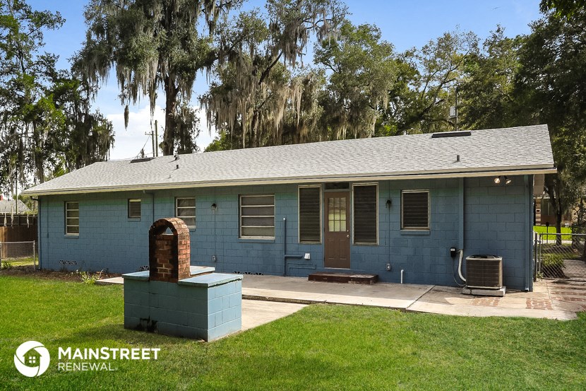 a blue house with a brick smoker in the front