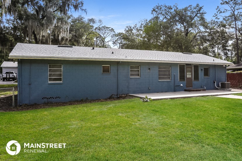 a blue house with a yard and a tree