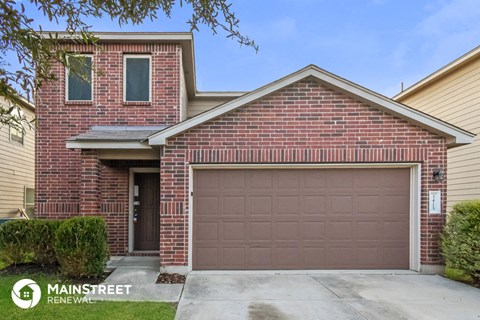 a brown garage door in front of a brick house