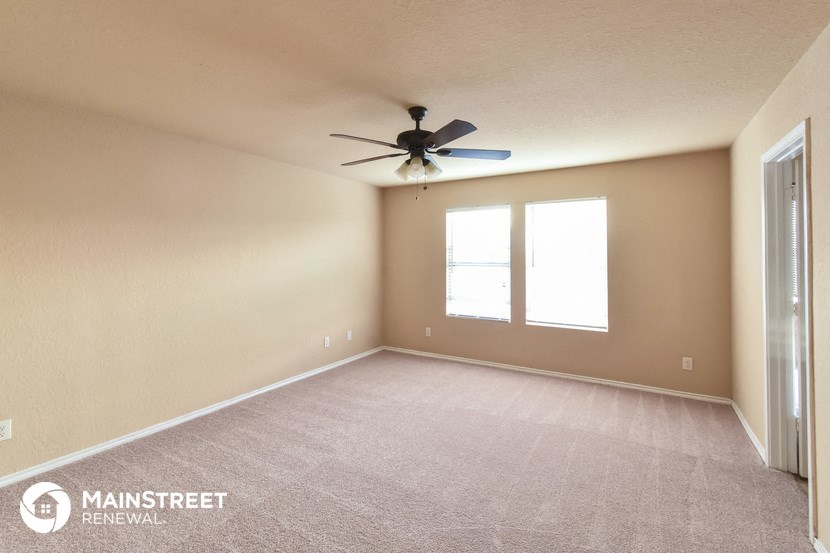 an empty room with a ceiling fan and a window