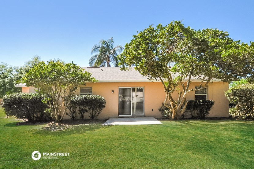 a small house with a lawn and trees