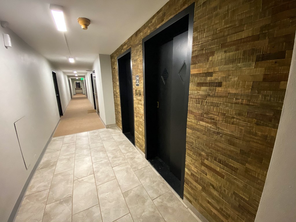 a hallway of elevators and doors in a building