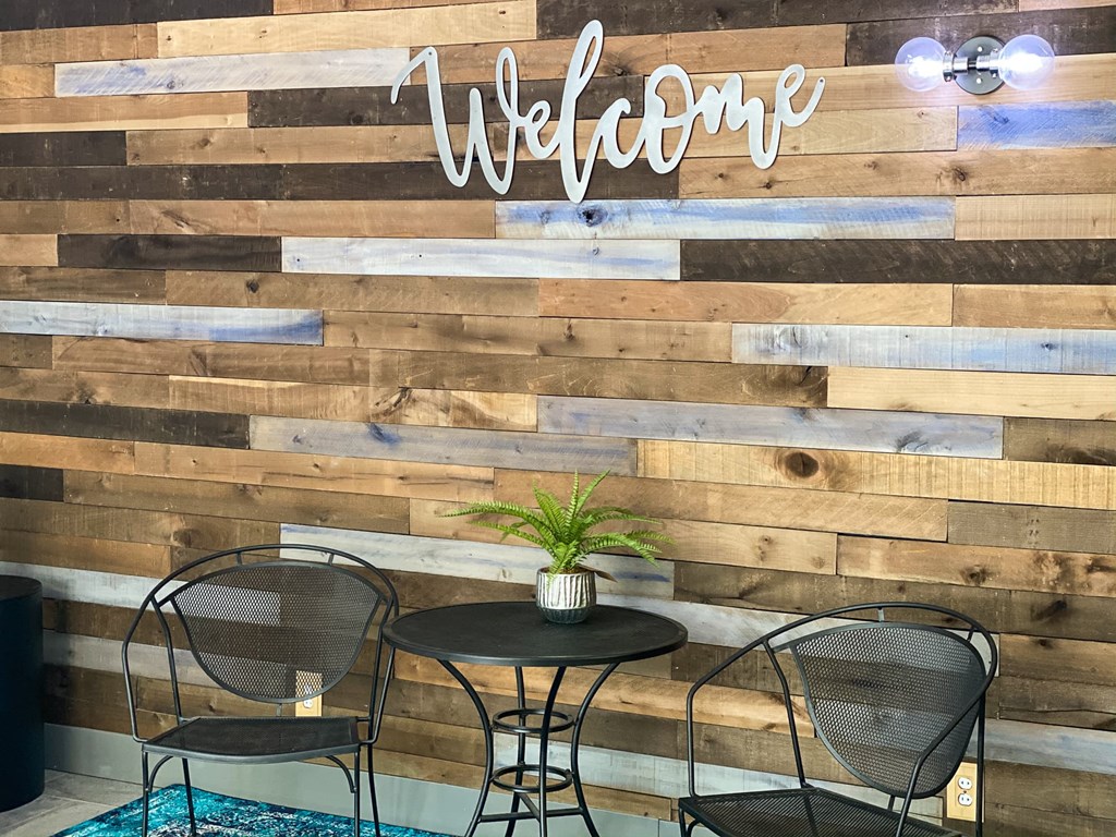 a table and chairs in front of a wooden wall