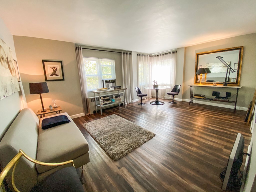a living room with a couch and a desk and a mirror
