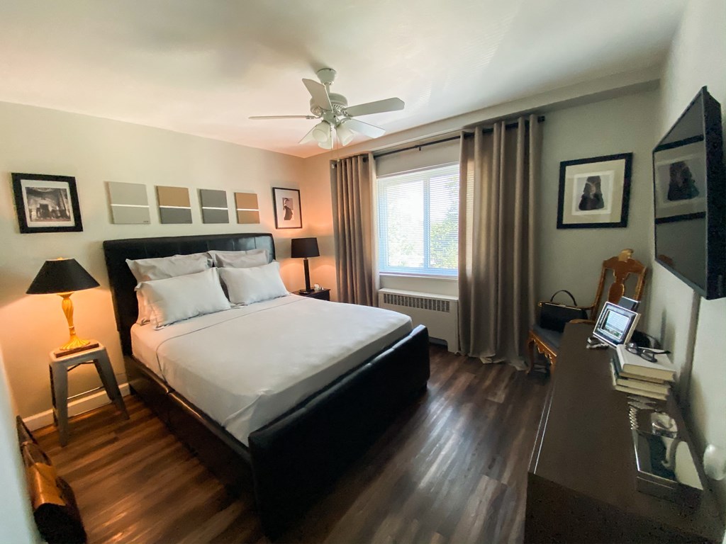 the master bedroom has a large bed and a large window