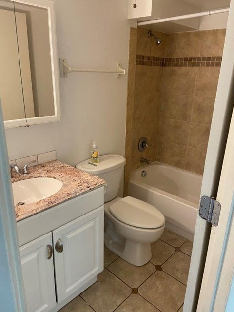 A bathroom with a toilet, sink, and bathtub.