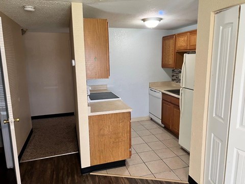 A kitchen with white appliances and wooden cabinets.
