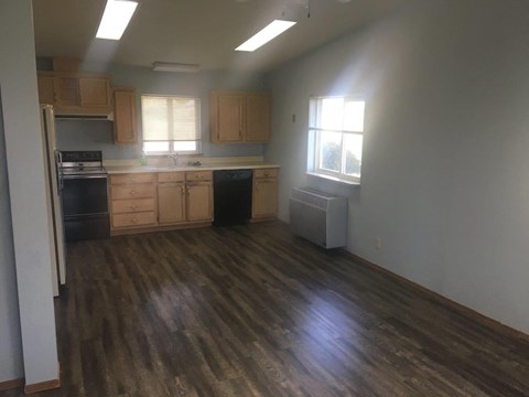 A kitchen with wooden floors and cabinets.