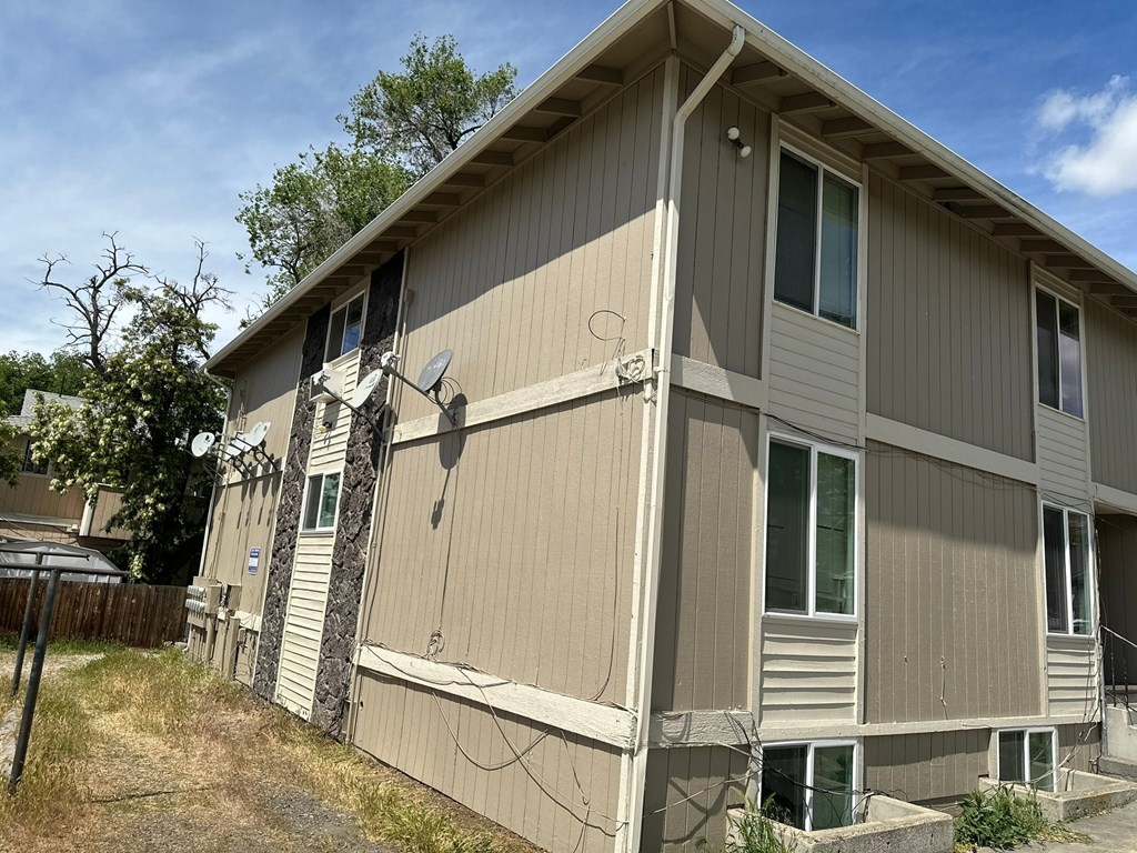 A beige house with a satellite dish on the roof.