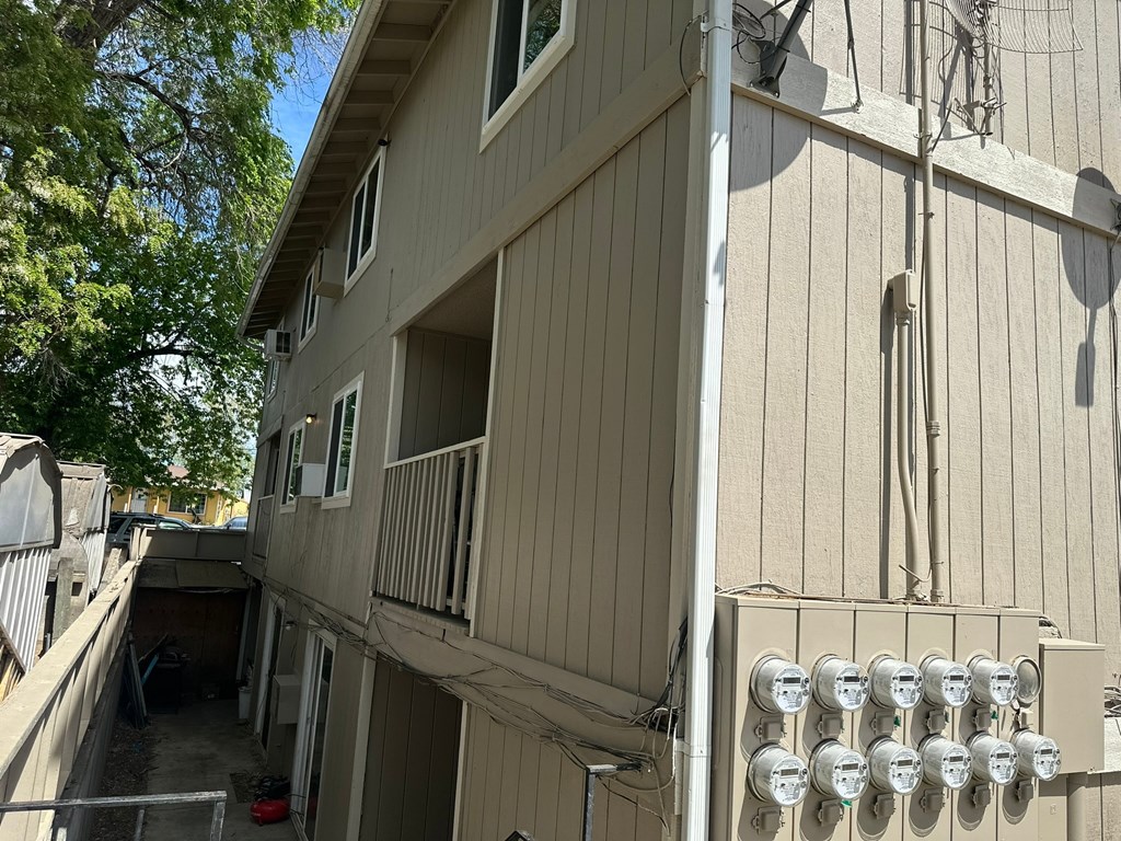 A building with a balcony and satellite dishes on the roof.