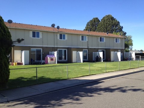 A row of houses with a fence in front.