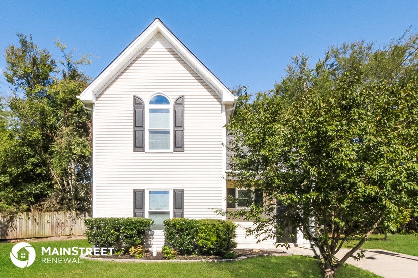 a white house with a tree in front of it