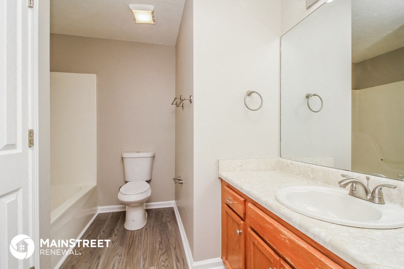 a bathroom with a toilet and a sink and a mirror