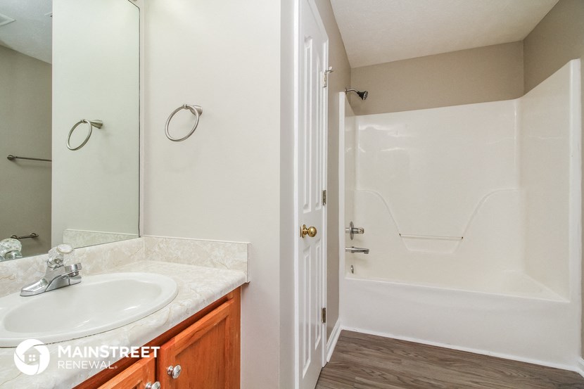 a bathroom with a sink and a shower and a mirror